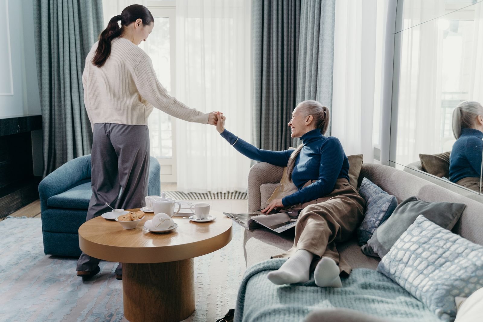 An adult daughter assisting her elderly mother at home